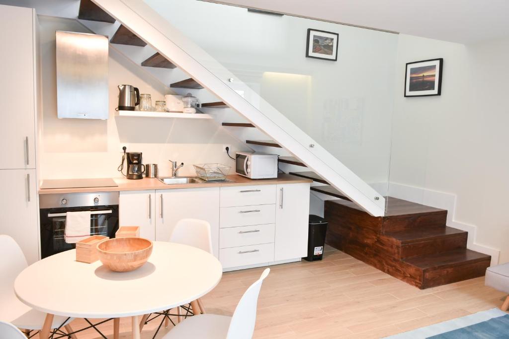 波尔图Typical Quarter Nest的白色的厨房,配有桌子和楼梯