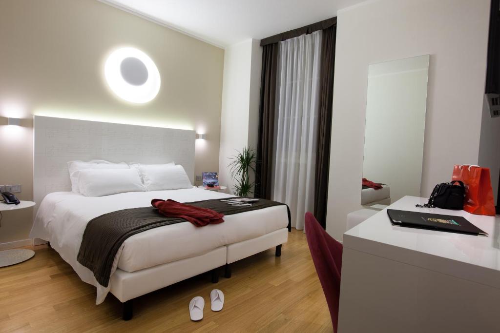 的里雅斯特Hotel Coppe Trieste - Boutique Hotel的一间酒店客房,一间设有一张床和一张书桌