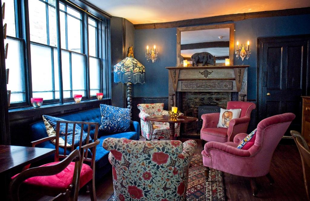布里奇沃特The Old Vicarage Hotel & Restaurant的客厅配有椅子、桌子和壁炉