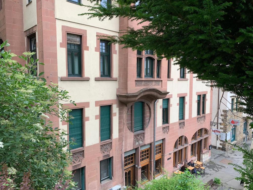 蒂宾根Ferienzimmer Tübingen的街道上一座粉红色的建筑,设有绿色百叶窗