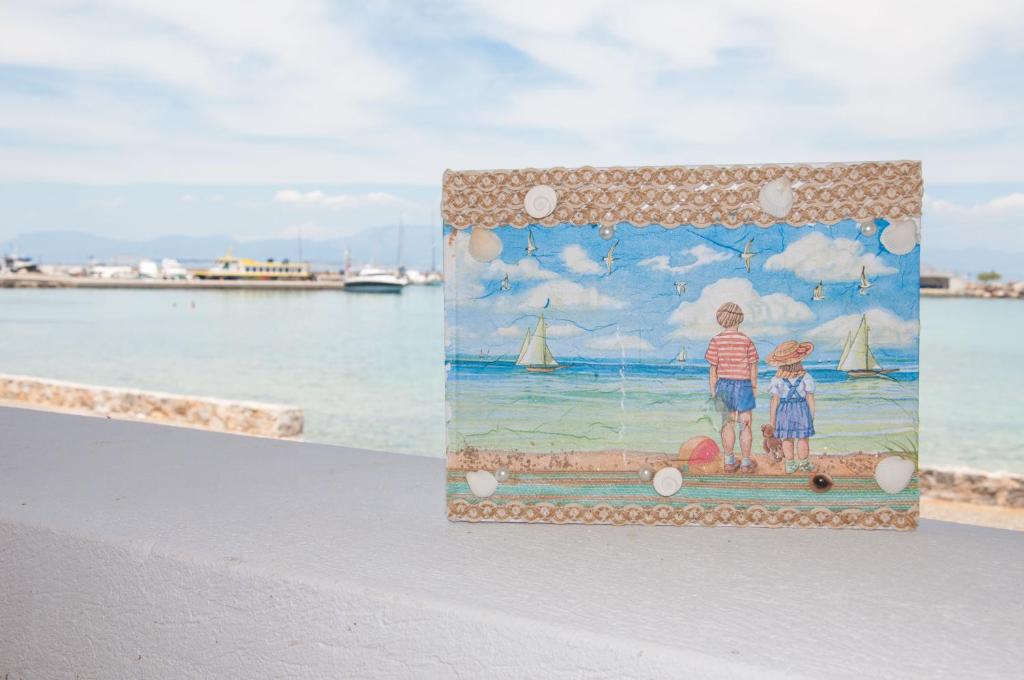 迈加洛丘里Nautilus Nontas Hotel的一张画画,画着两个站在海滩上的孩子