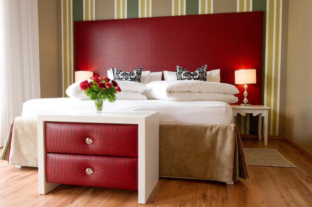 斯瓦科普蒙德纳米布宾馆 的一间卧室配有一张大床和红色床头板