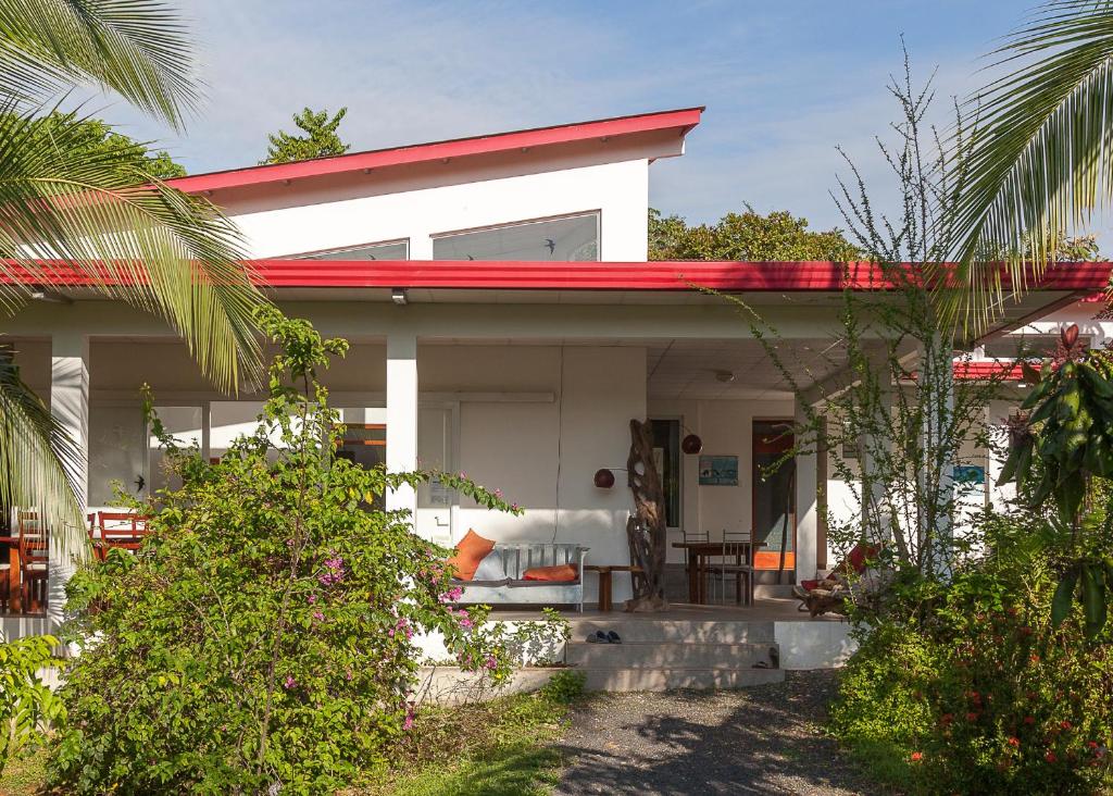 MalenaHotel Heliconia Panamá的一间白色的小房子,有红色的屋顶