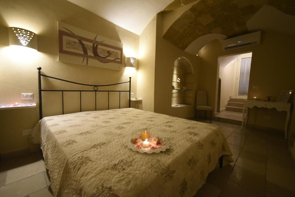 加利波利B&B Corte Cantalupi的一间卧室配有一张带蜡烛的床。