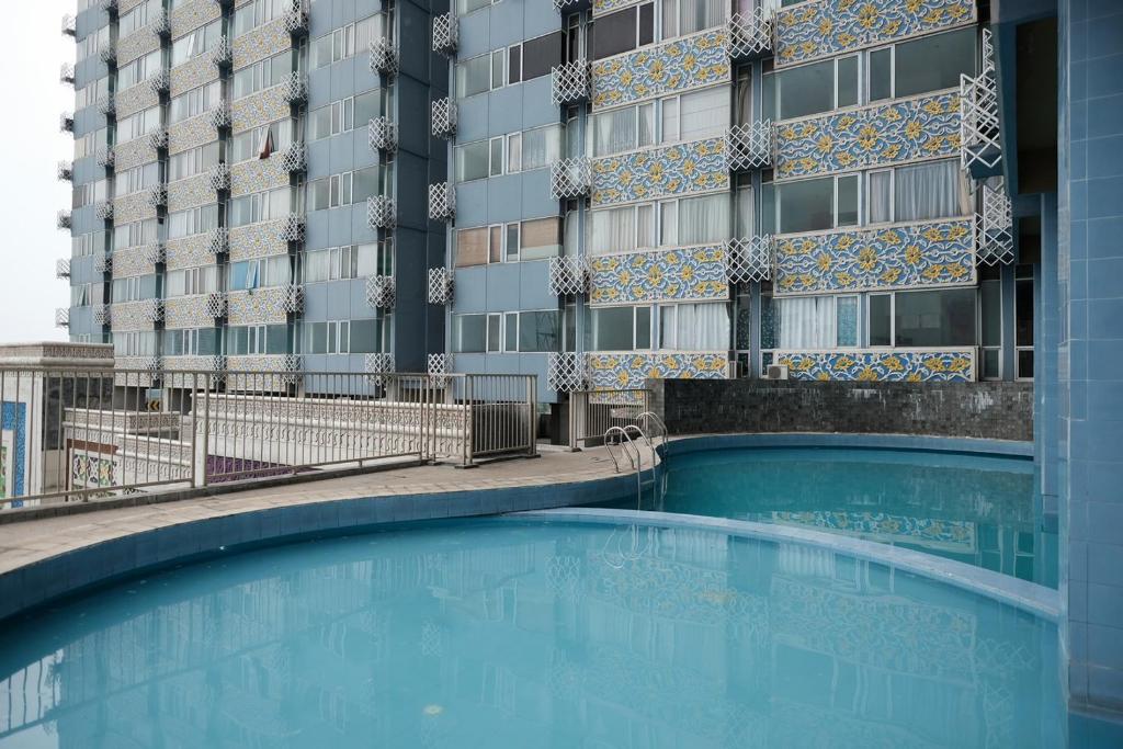 德波RedLiving Apartemen Saladdin Mansion - RAN Management的大楼前的大型游泳池