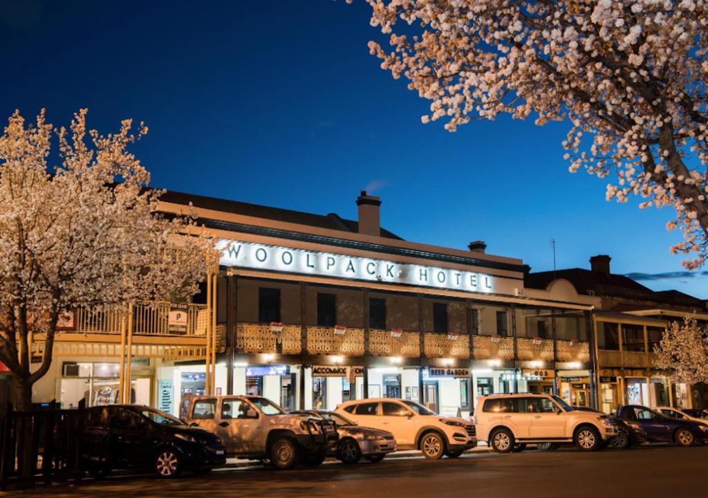 马奇The Woolpack Hotel的前面有汽车停放的建筑