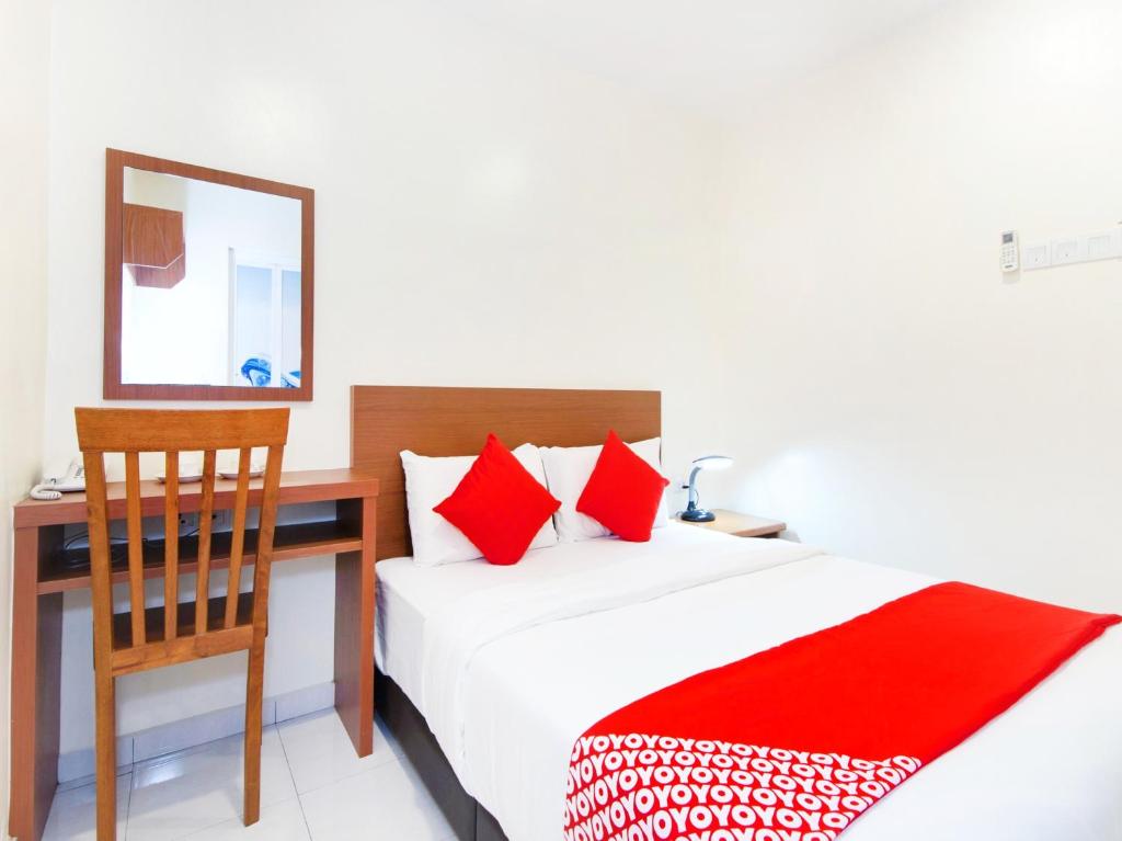马六甲Lawten Hotel的一间卧室配有书桌、一张床和一把椅子