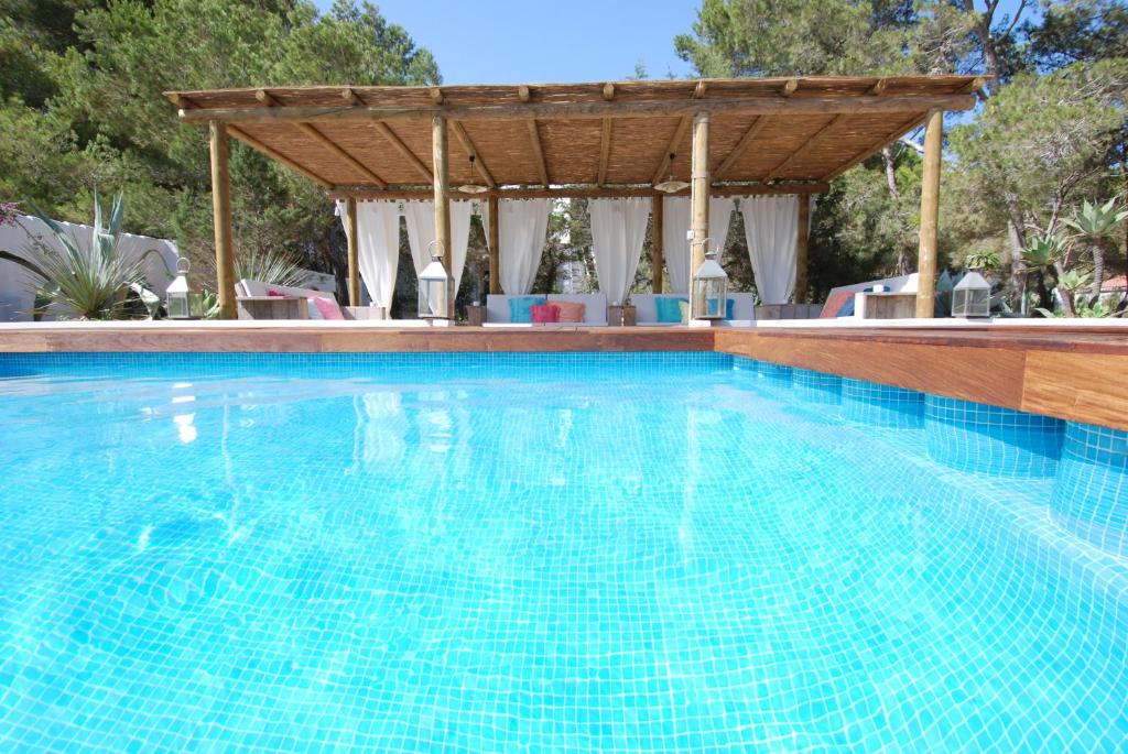 圣费兰-德瑟斯罗La Hacienda的一个带木制凉棚的游泳池和一个游泳池