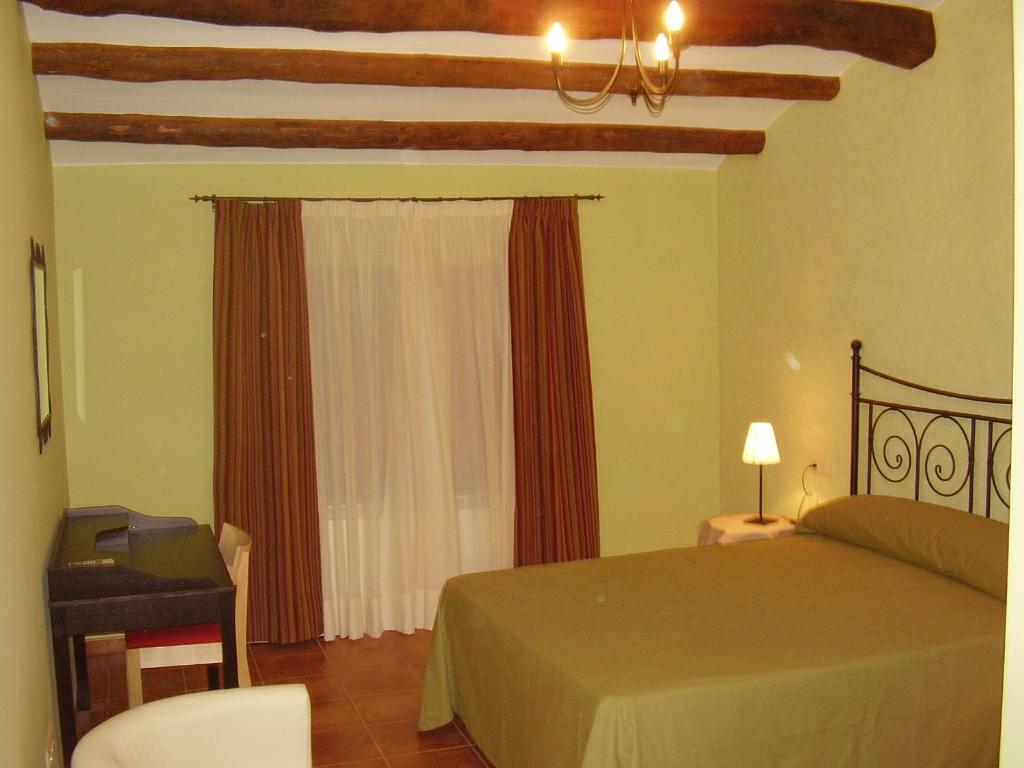 AlborgeCasa De Los Diezmos的一间卧室配有一张床、一张书桌和一个窗户。
