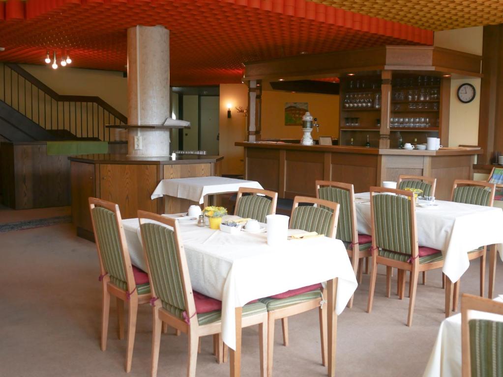 科布伦茨Hotel Oronto的一间带2张桌子和椅子以及炉灶的餐厅