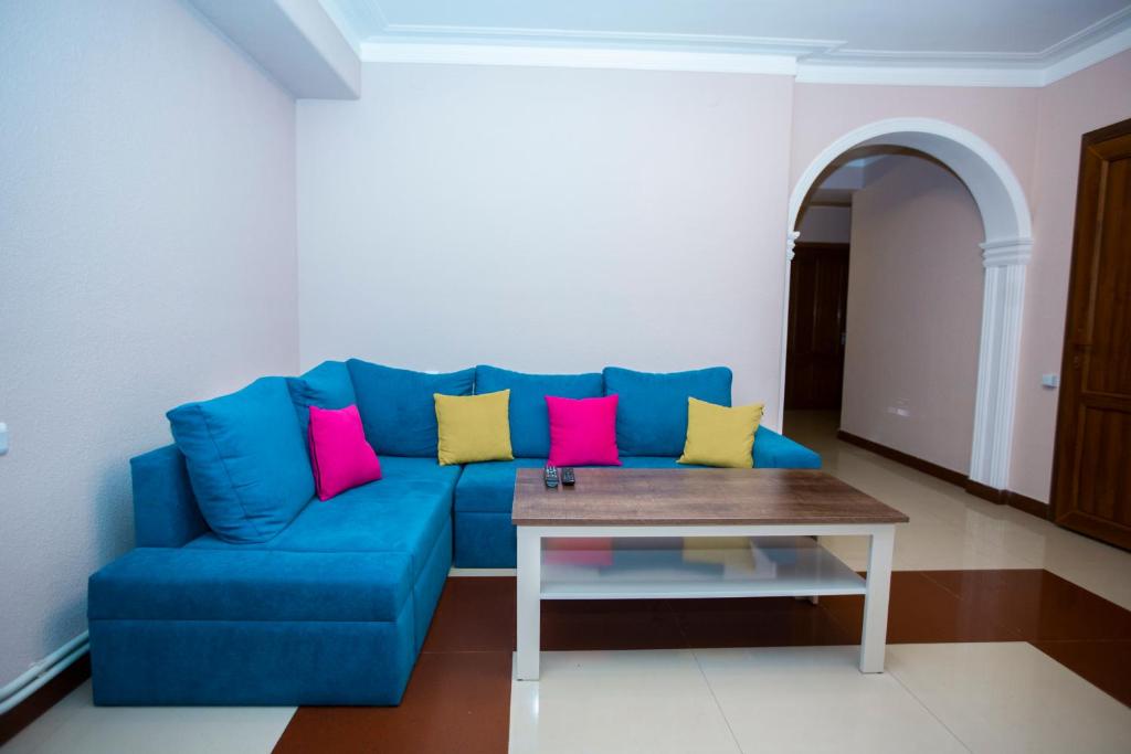 埃里温Sweet Sleep hostel的客厅里配有带色彩缤纷枕头的蓝色沙发