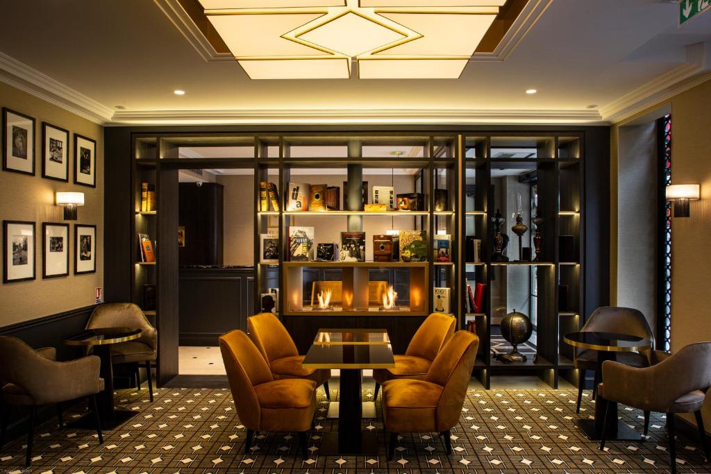 巴黎乐诺巴纳斯峰酒店的一间餐厅,在房间内配有椅子和桌子