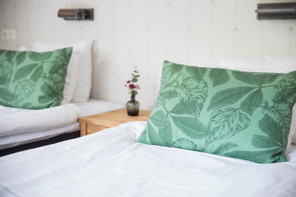 斯德哥尔摩辛肯丹姆STF酒店的一间卧室配有一张带绿色枕头的床和一张沙发