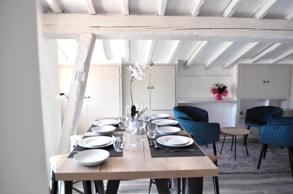 科利尤尔Ibanova Appartements的一间带木桌和蓝色椅子的用餐室