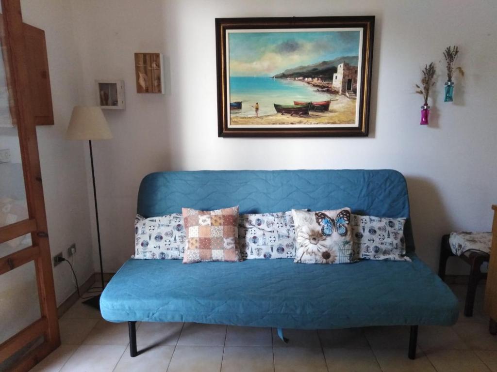 托里德欧索Casa Poesia的客厅里一张蓝色的沙发,上面有绘画作品