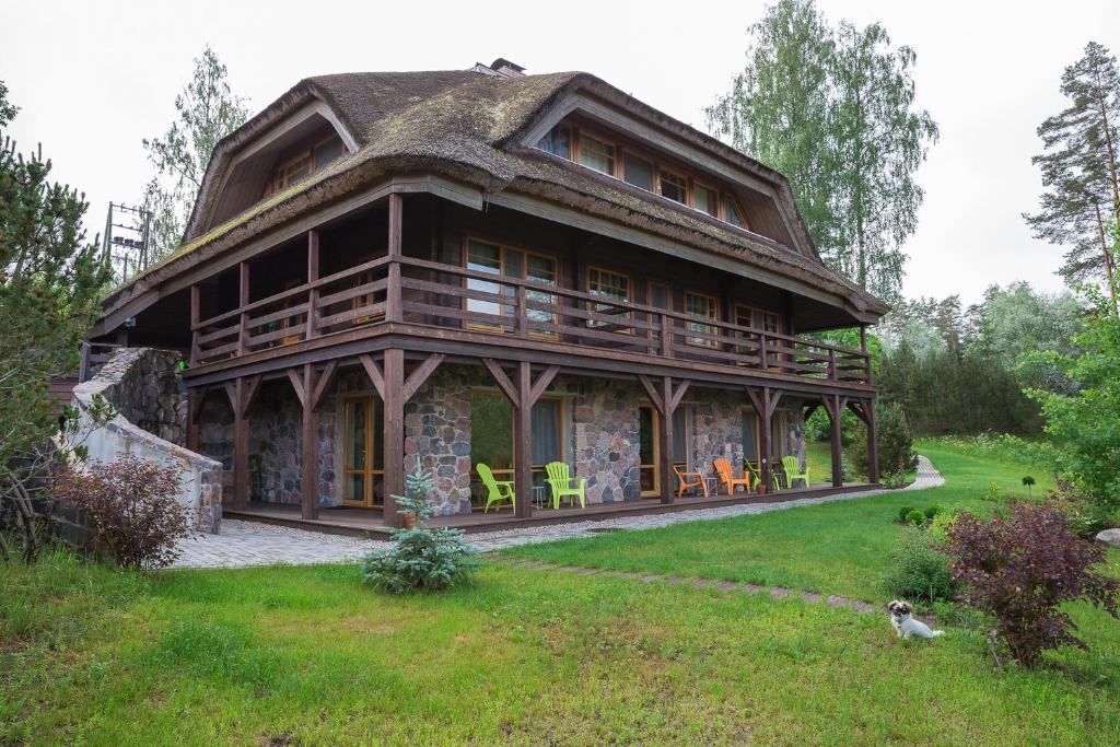 AmatciemsDzeņi的大型小木屋,设有茅草屋顶