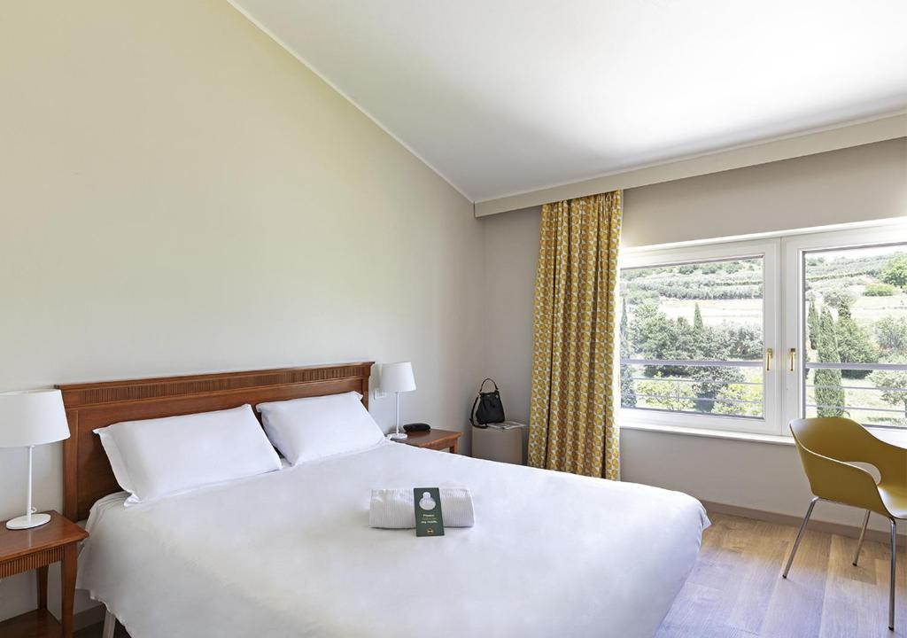 阿菲B&B Hotel Affi - Lago di Garda的卧室设有一张白色大床和一扇窗户。