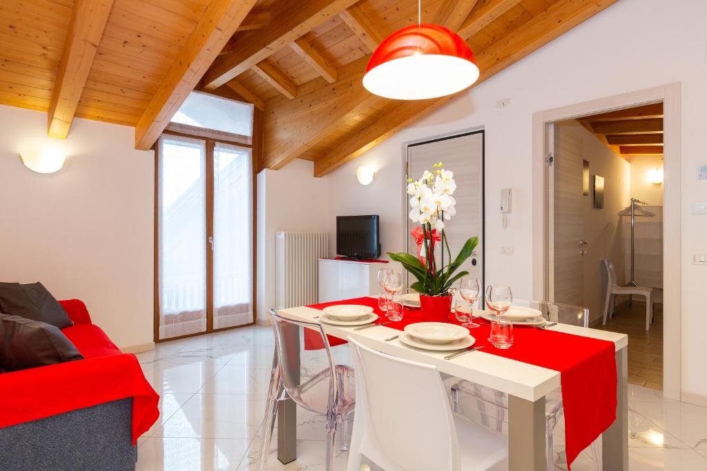 阿科Residenza San Rocco的客厅配有桌子和红色沙发