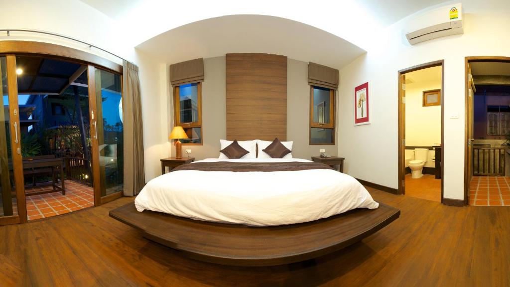 通萨拉Dreamville Koh Phangan的一间卧室设有一张大床,铺有木地板