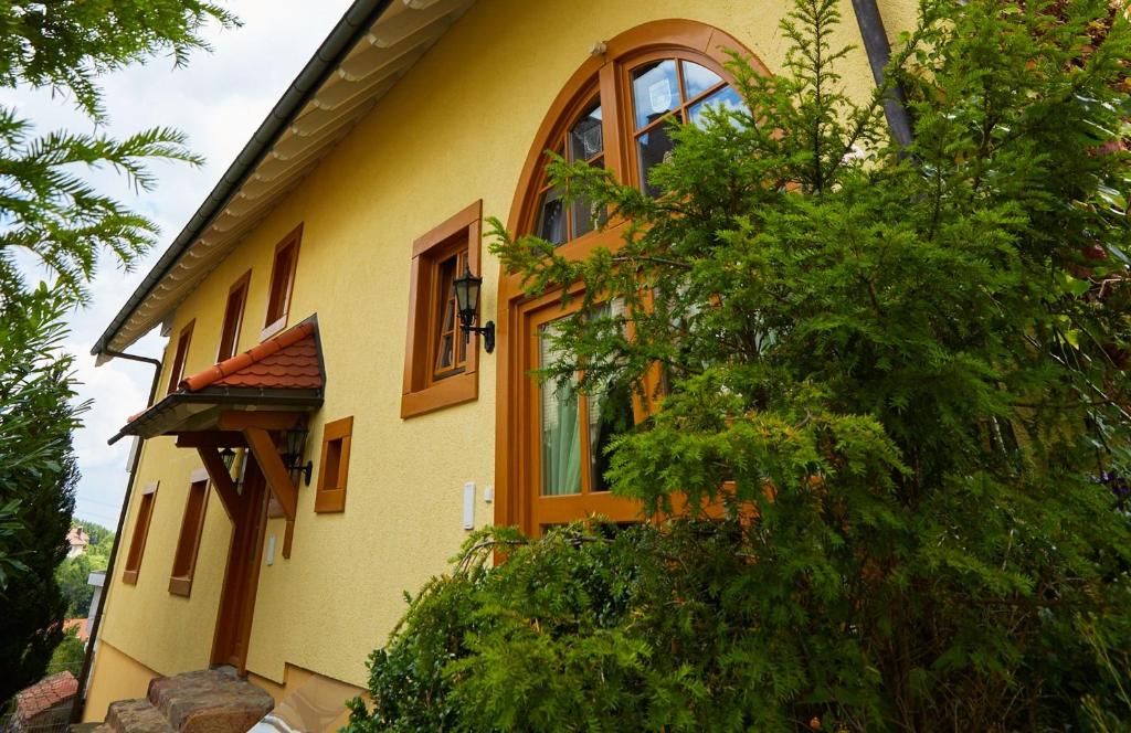 勒芬根Villa Grenzenlos的黄色的房子,旁边设有大窗户