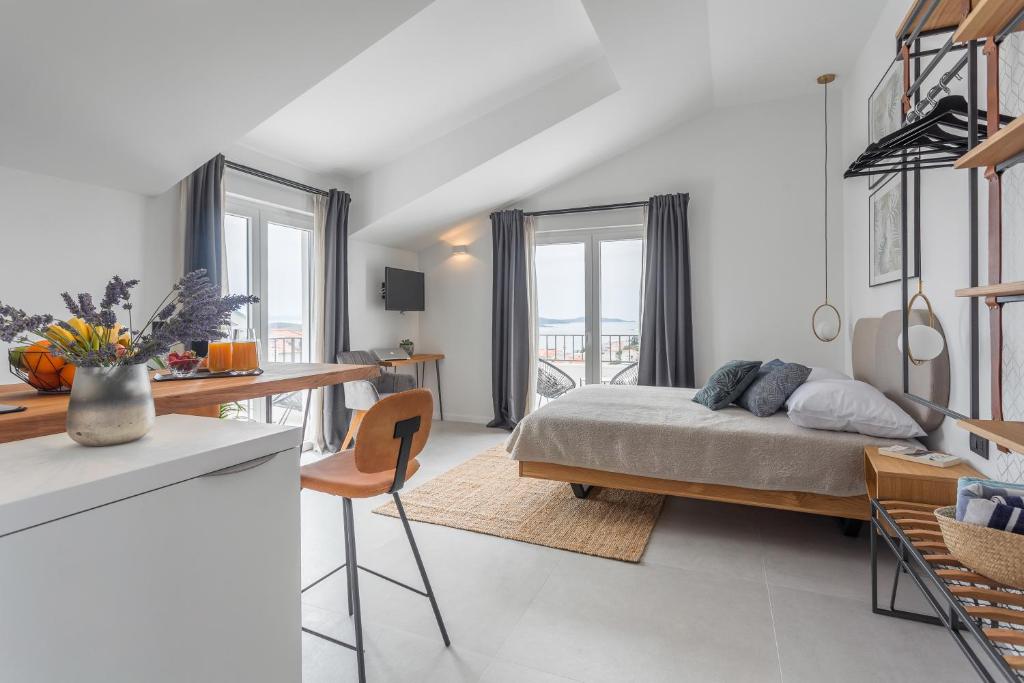 赫瓦尔Hvar Top View Apartments的一间带一张床和一张书桌的卧室和一间厨房