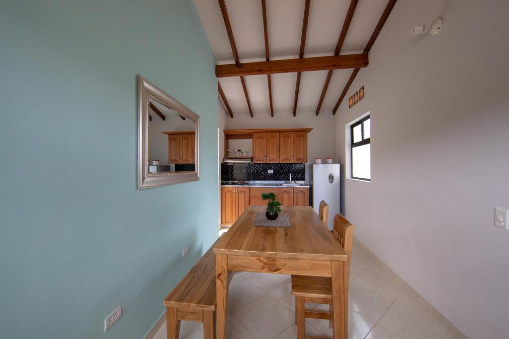 贾丁Apartamentos Primavera的厨房配有木桌和冰箱。
