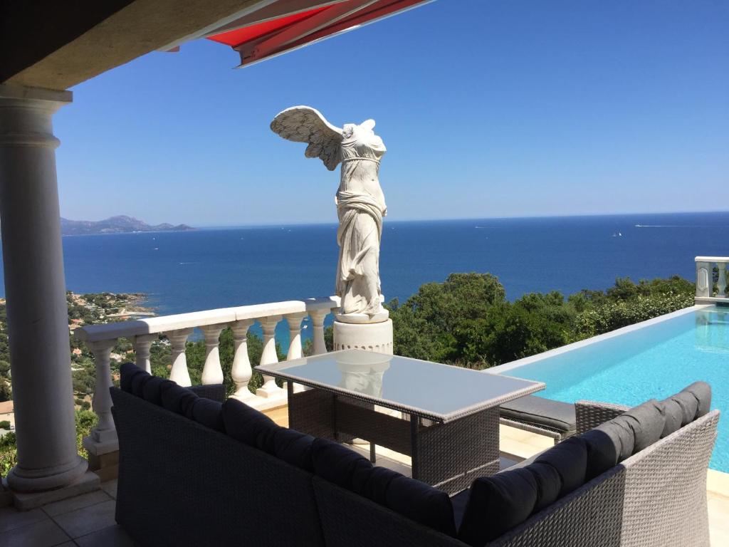 雷以桑布尔Villa Goonie的天使雕像站在泳池旁的阳台
