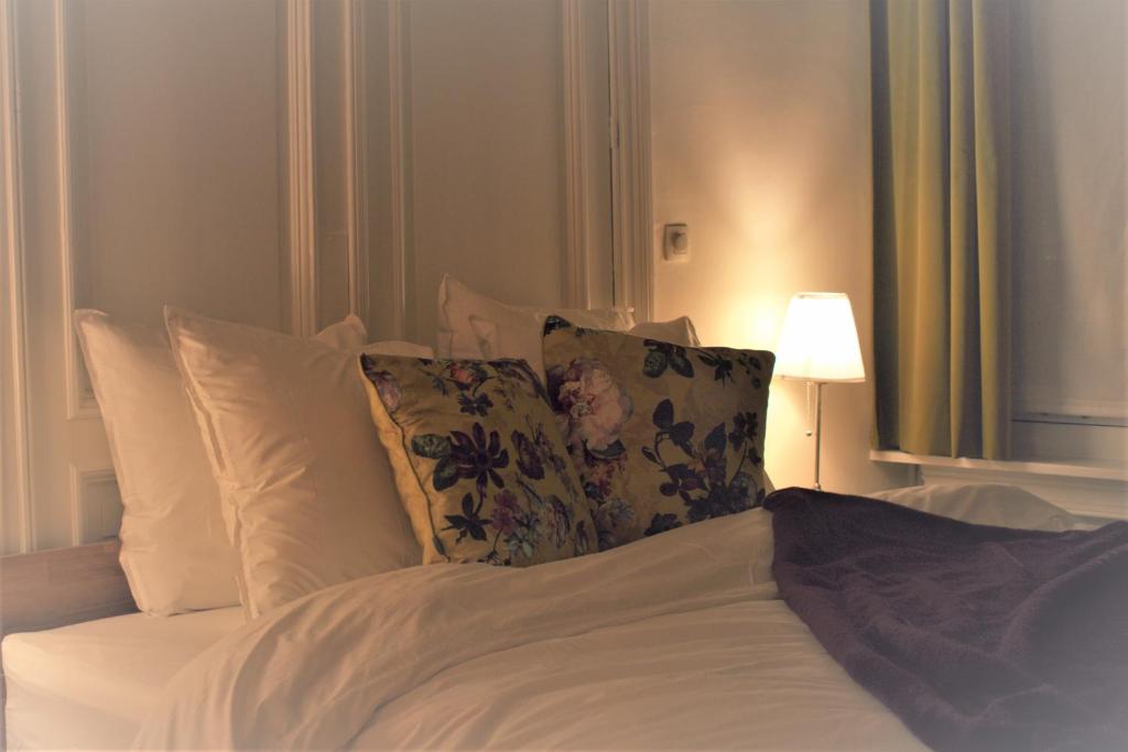 安特卫普Quiet apartment in Antwerp near parc - B&B InterMezzo - business & leisure的一张带白色床单和枕头的床以及一盏灯