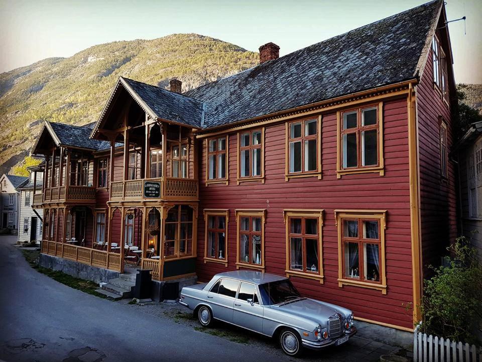 莱达尔绥里Lærdalsøren Motor Guesthouse的停在木结构建筑前的旧车