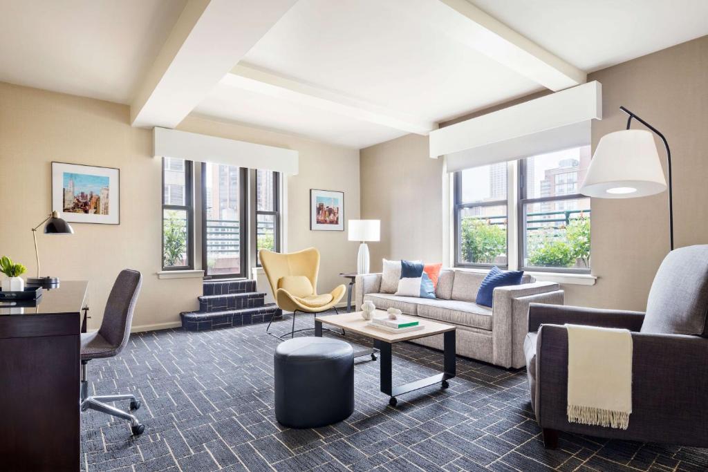纽约The Shelburne Sonesta New York的带沙发和椅子的客厅以及窗户。