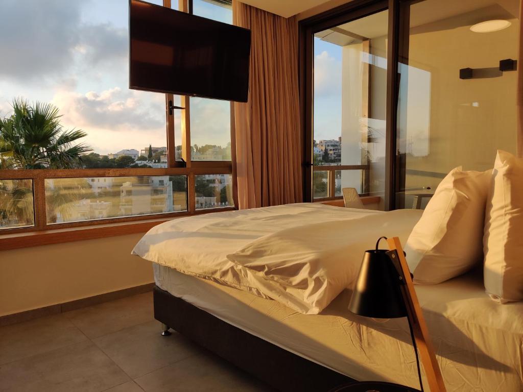 海法Luxury Suites by Notaly Ariel的一间卧室设有一张床和一个大窗户