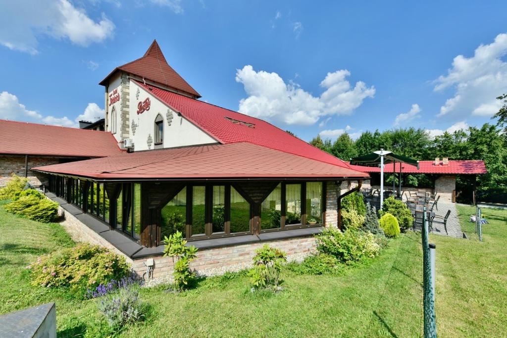 Horní TěrlickoWellness Hotel Fridrich的一座红色屋顶和庭院的建筑