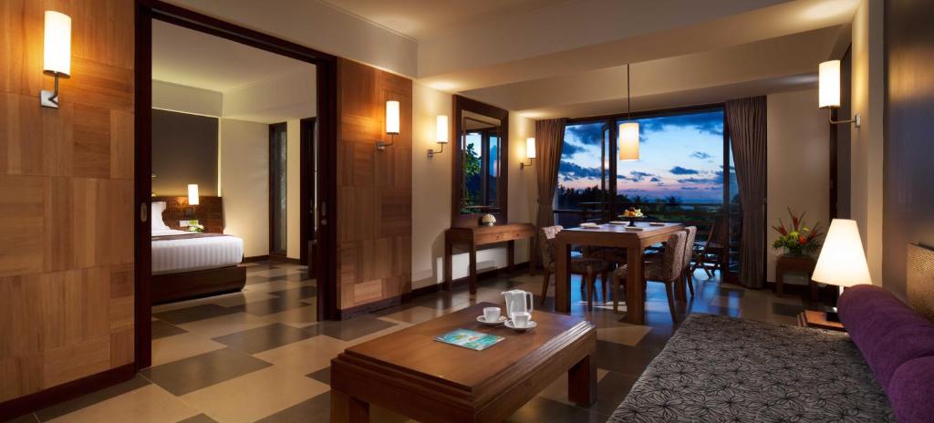 库塔库塔太阳岛酒店及Spa中心的客厅设有一张床和一张桌子