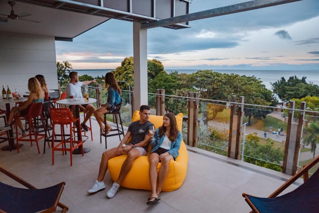 凯恩斯Global Backpackers Cairns的一群人坐在阳台上的豆袋椅上