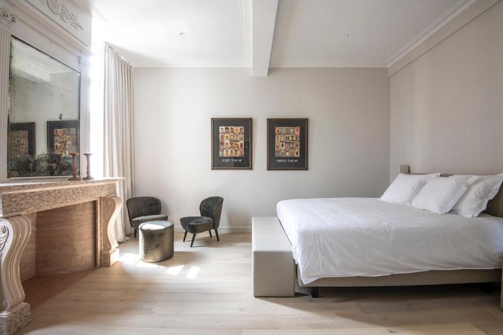 奥德纳尔德Bed & Breakfast Jezuietenplein 21的卧室配有白色的床和壁炉