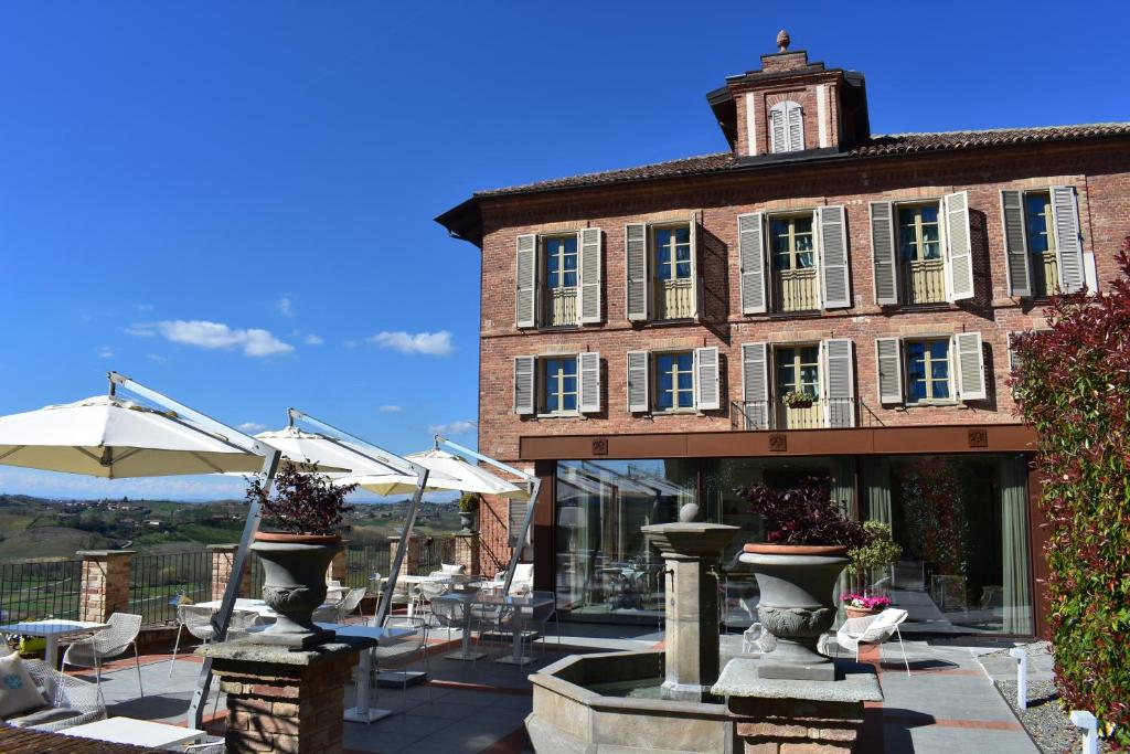 阿利亚诺泰尔梅Villa Fontana Relais Suite & Spa的前面有桌子和伞的建筑