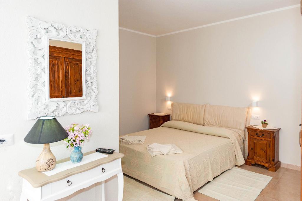 圣特奥多罗B&B Lu Lioni的卧室配有一张床,墙上设有镜子