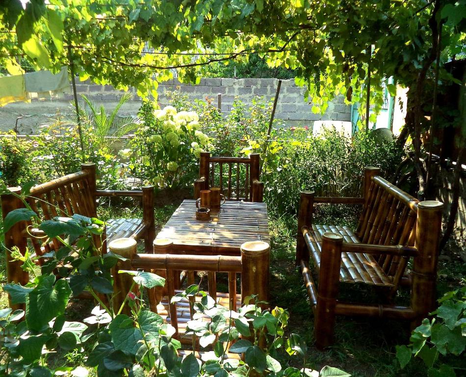 博尔若米Guest House Metreveli的花园里的一张木桌和椅子