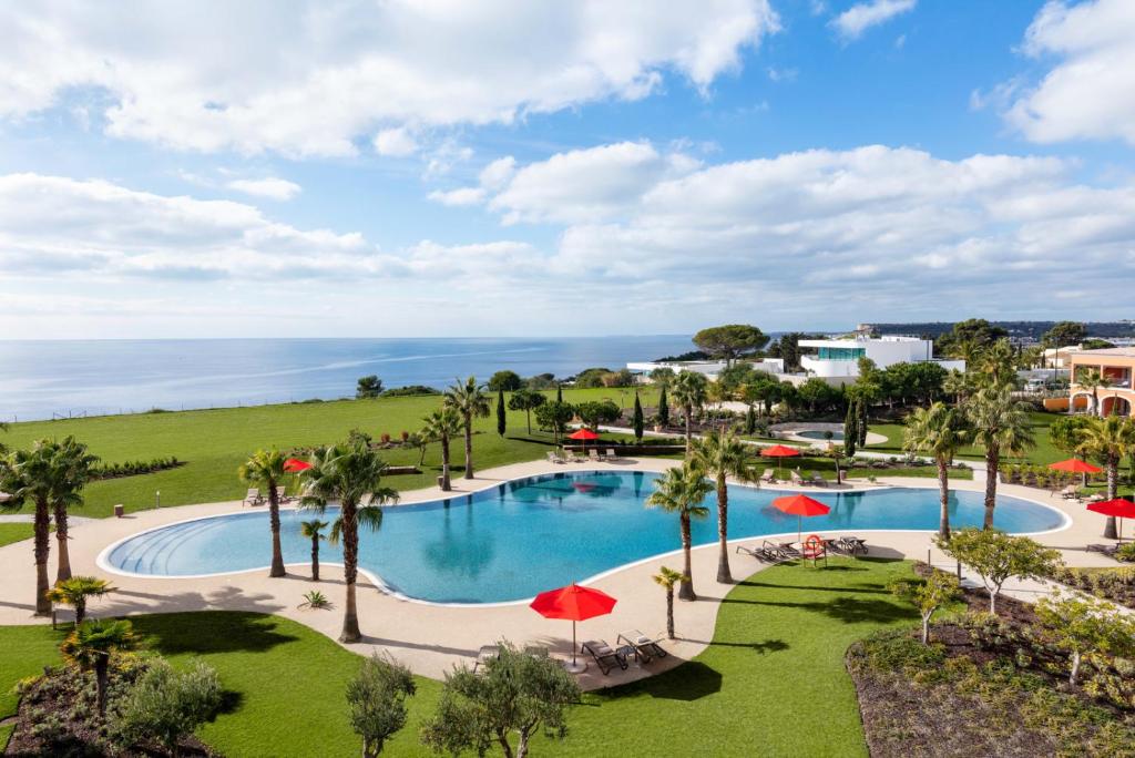 拉戈斯Cascade Wellness Resort的享有棕榈树游泳池和大海的顶部景致