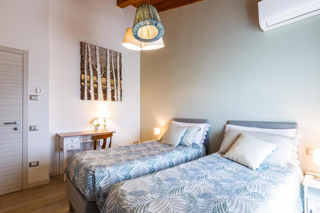 Galliera VenetaB&B ARMONIE DI CAMPAGNA的一间卧室配有两张床和一张带台灯的桌子