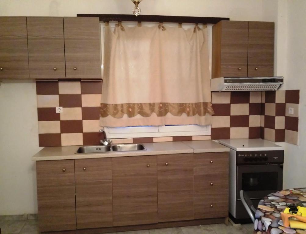 路特奇天堂之城一室公寓的厨房设有窗户、水槽和炉灶。