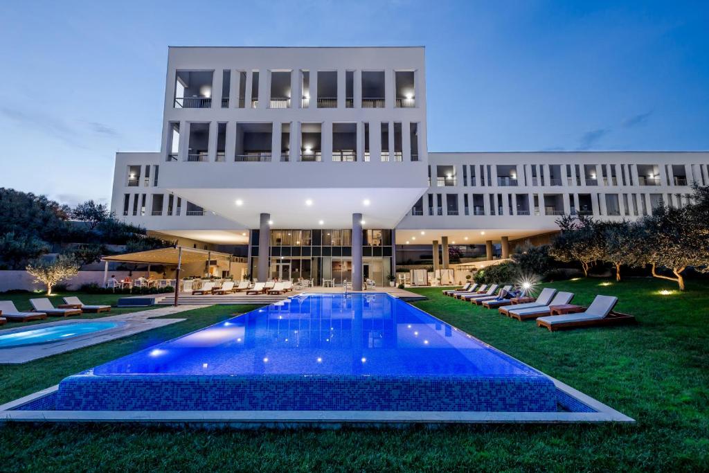 索林索罗那宫酒店的建筑前的一座带游泳池的建筑