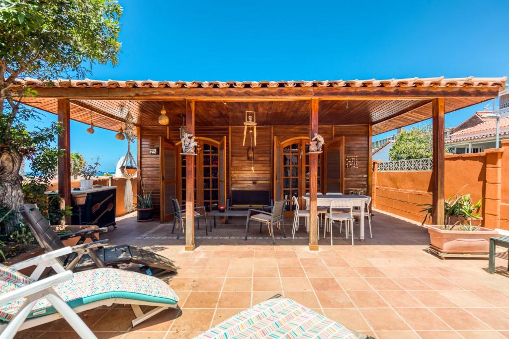 圣巴托洛梅Camping Cabin - Private Solarium & Pool - BBQ的天井上配有桌椅的凉亭