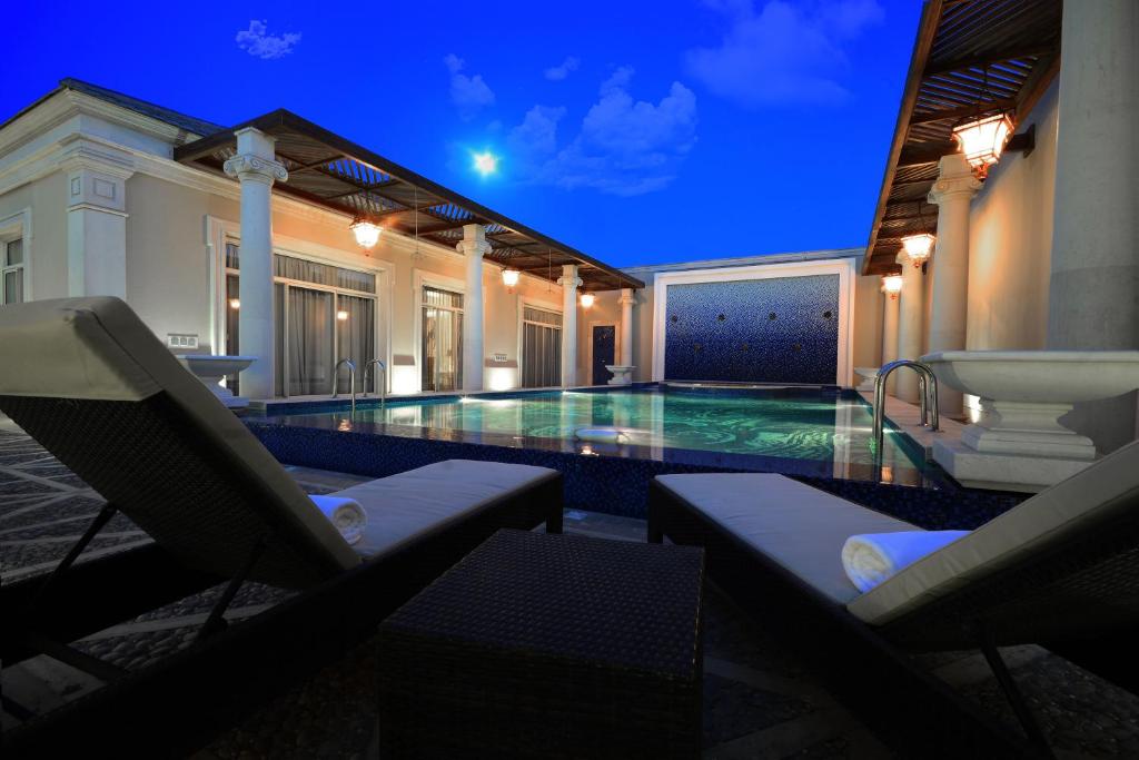 利雅德古特度假酒店的一个带椅子的游泳池,别墅