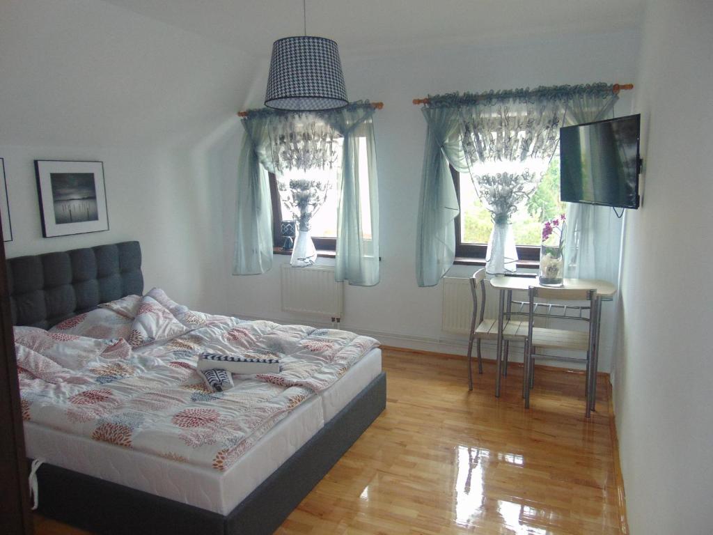 科沃布热格Willa IDYLLA的卧室配有床、桌子和窗户。