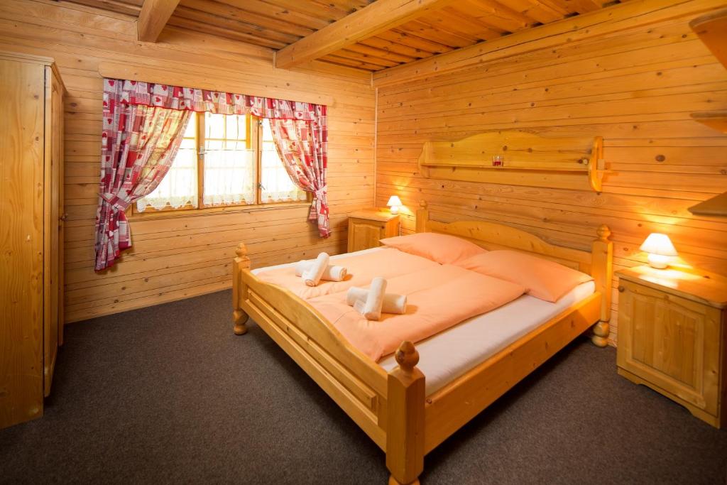 道尼库宾Apartmány Kubínska hoľa的小木屋内一间卧室,配有一张床