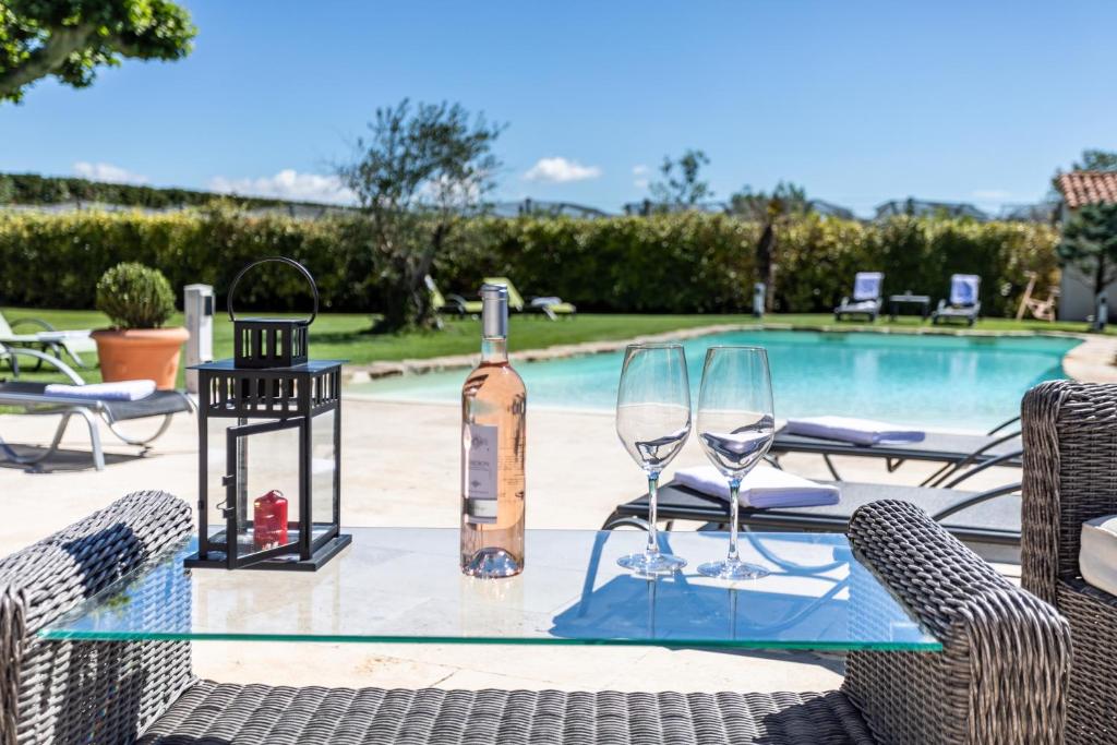 卡瓦永马斯圣朱利安酒店的玻璃桌,带一瓶葡萄酒和两杯