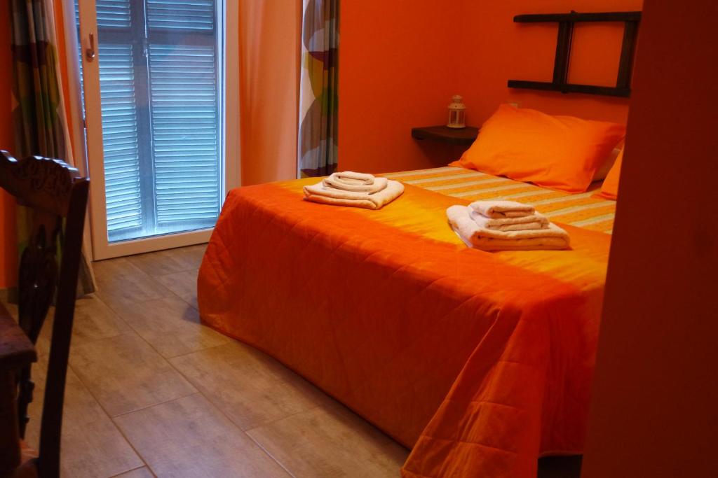 ZagaroloLA TERRAZZA SU ROMA的一间卧室配有橙色床和毛巾