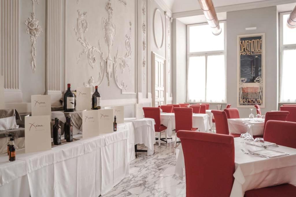 热那亚Hotel De Ville的用餐室配有白色的桌子和红色的椅子