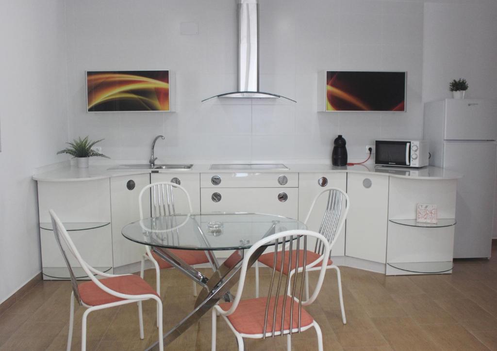 阿尔戈多纳莱斯Be happy Arco的厨房配有玻璃桌和两把椅子